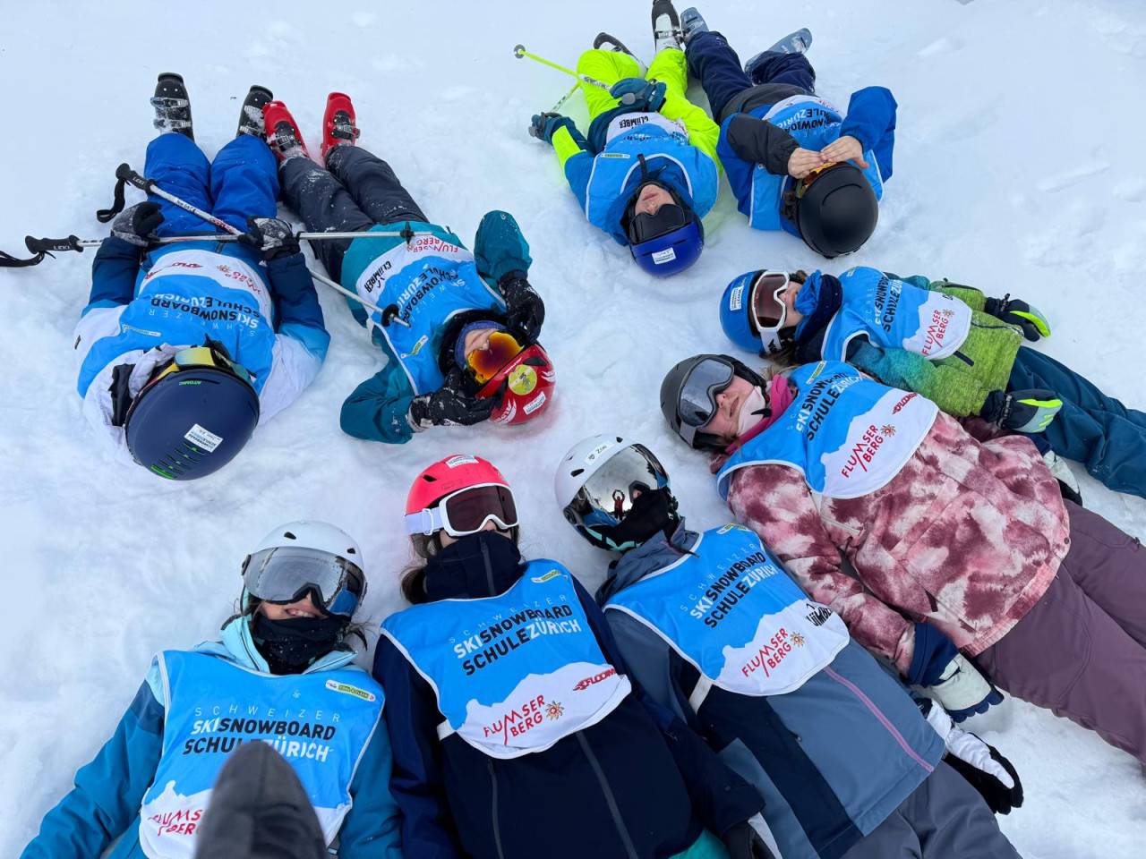 Skigruppe liegend im Schnee